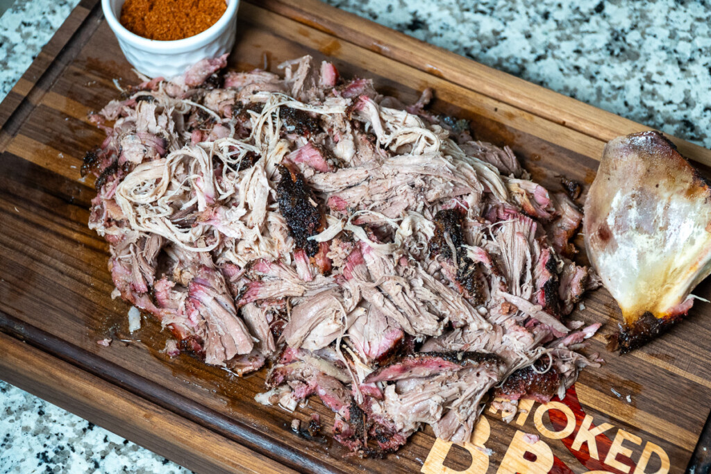 a shredded pork butt on a wooden board