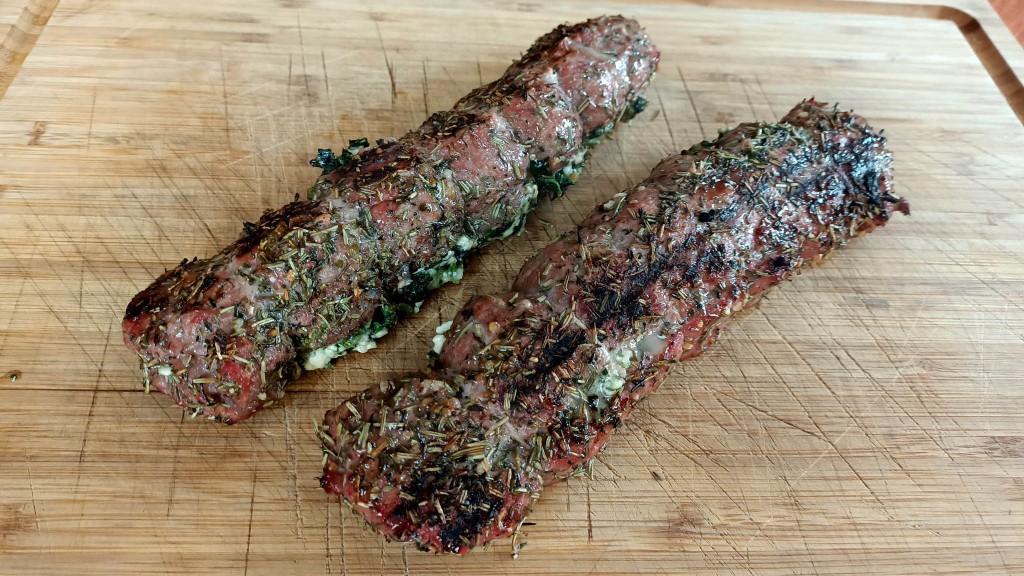 stuffed lamb backstraps on a wooden board