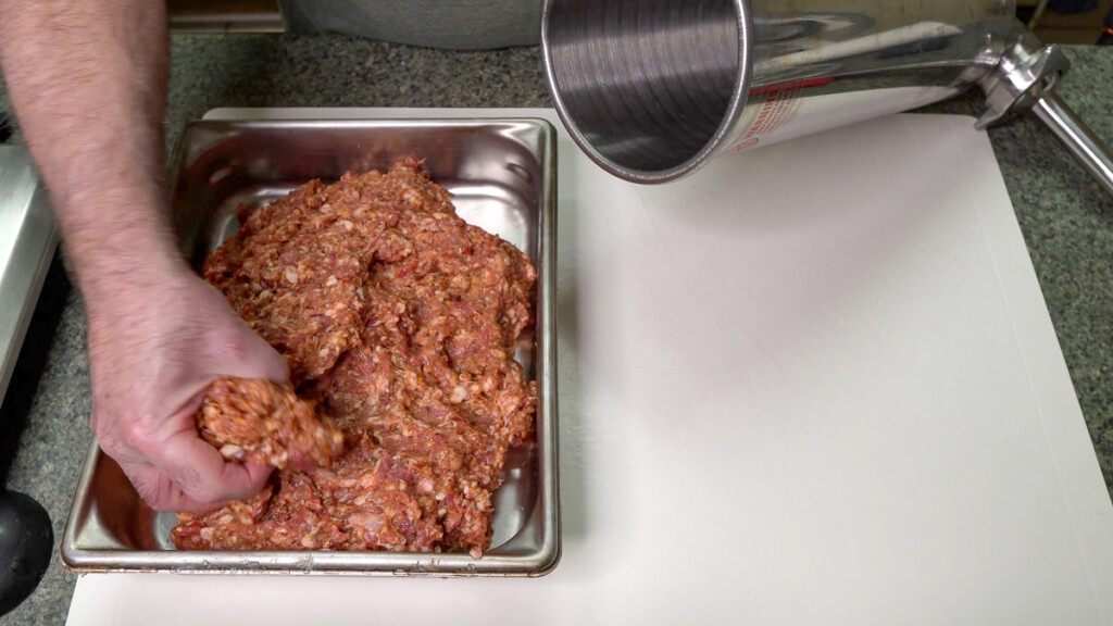 meat being fed into sausage stuffer