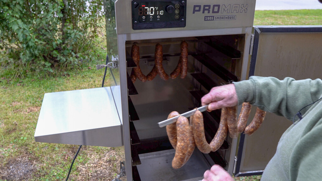 a rack of sausage links going into smoker