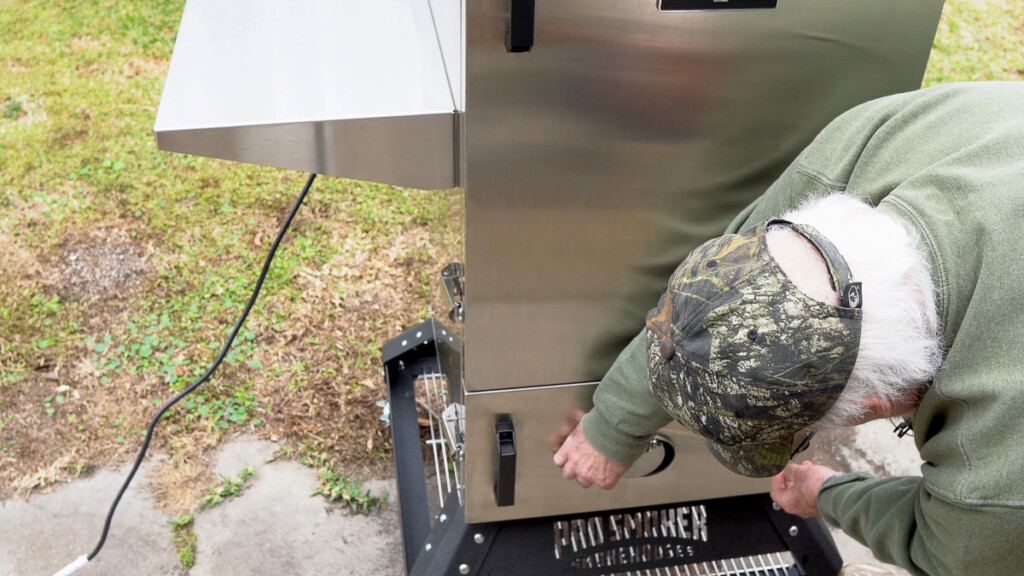 a man closing the bottom vent on smoke