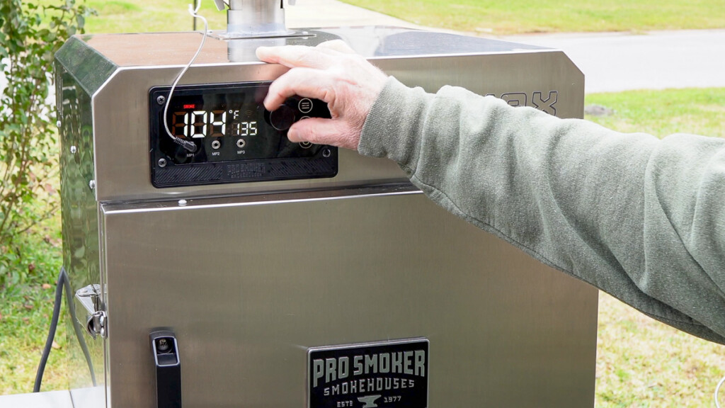 a man setting the temperature on the smoker to135°F