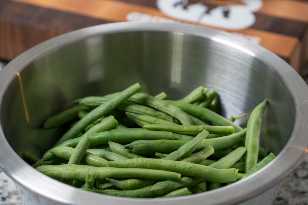 fresh green beans in a metal bowl