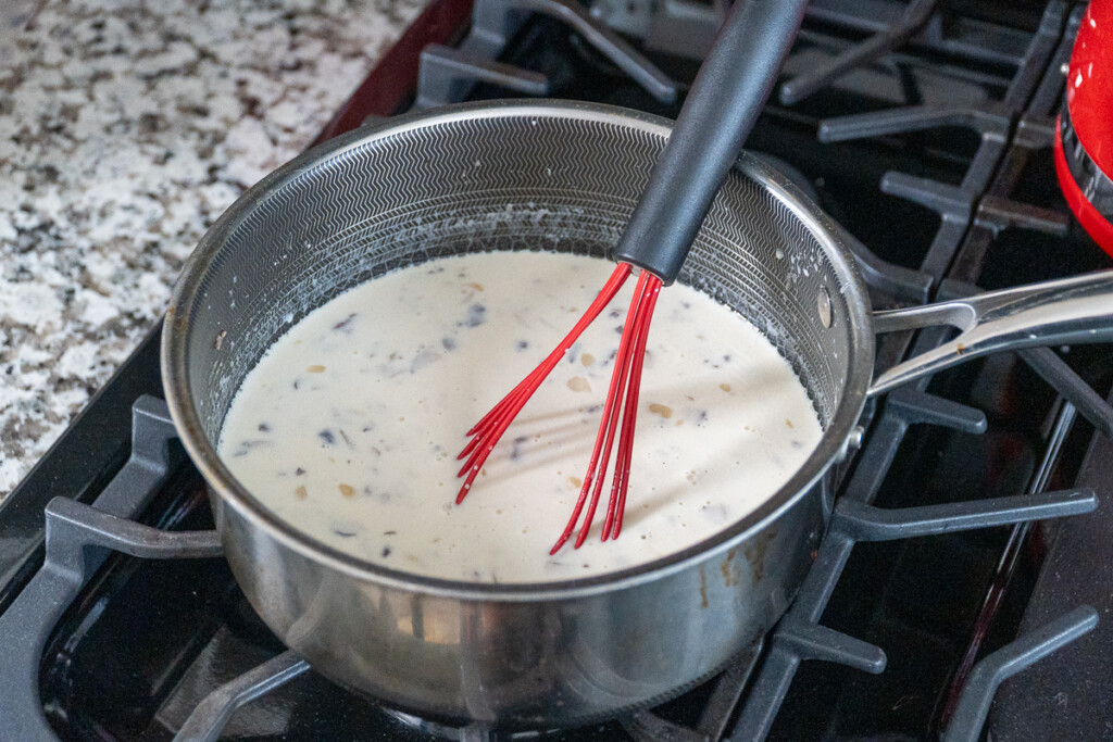 mushroom soup in a pot with a whisk