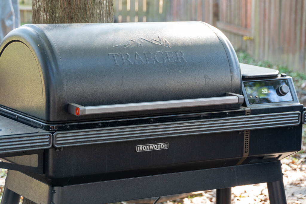 Close-up of a Traeger Ironwood XL pellet smoker grill outdoors, showing the Traeger logo on the lid and the digital temperature display set to 223°F on the control panel.