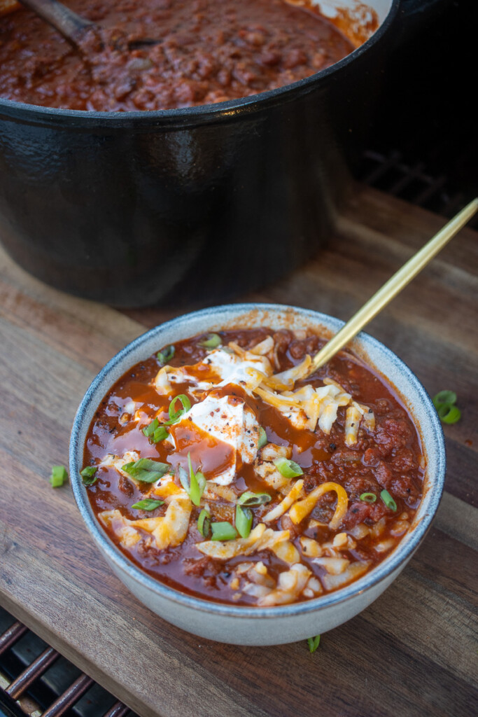 a bowl of smoked over the top chili with a spoon in it