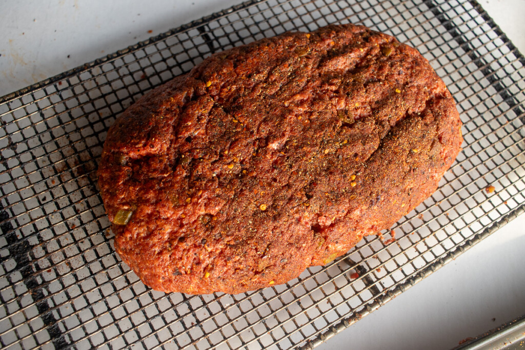 a slab of ground beef on a wire rack