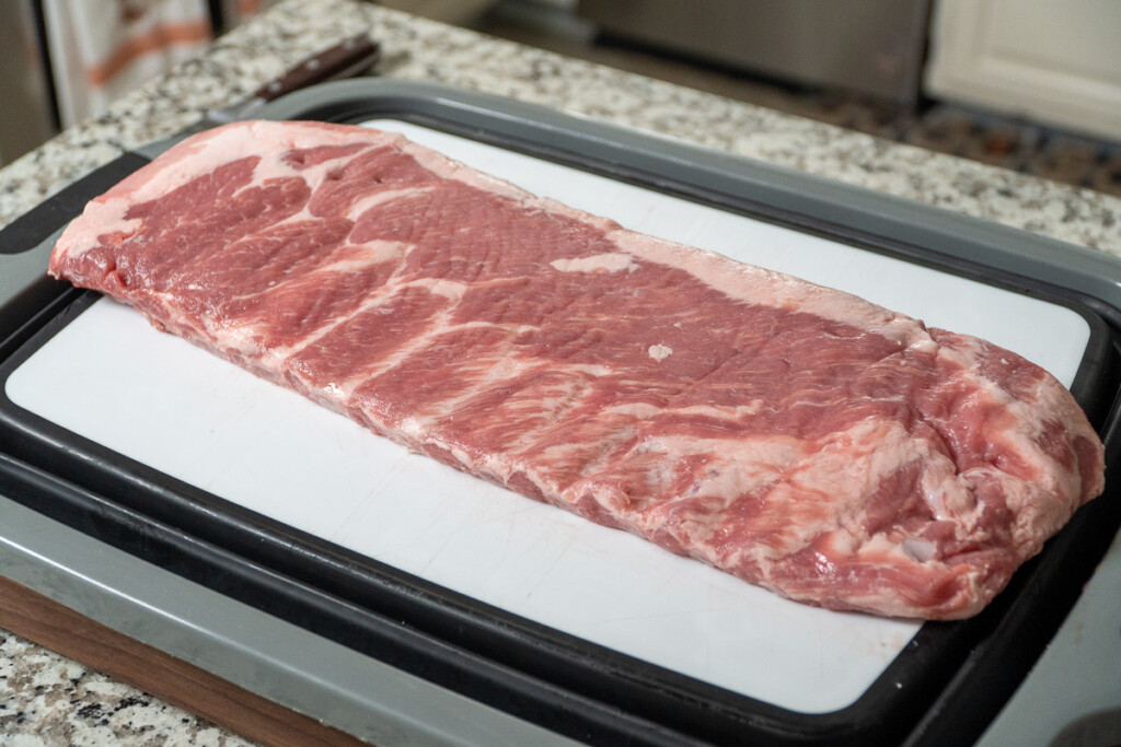 a rack of raw st louis ribs on a white board