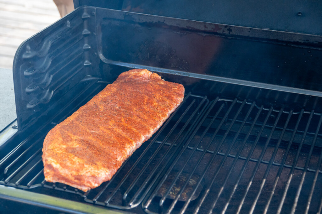 a raw rack of ribs in the smoker