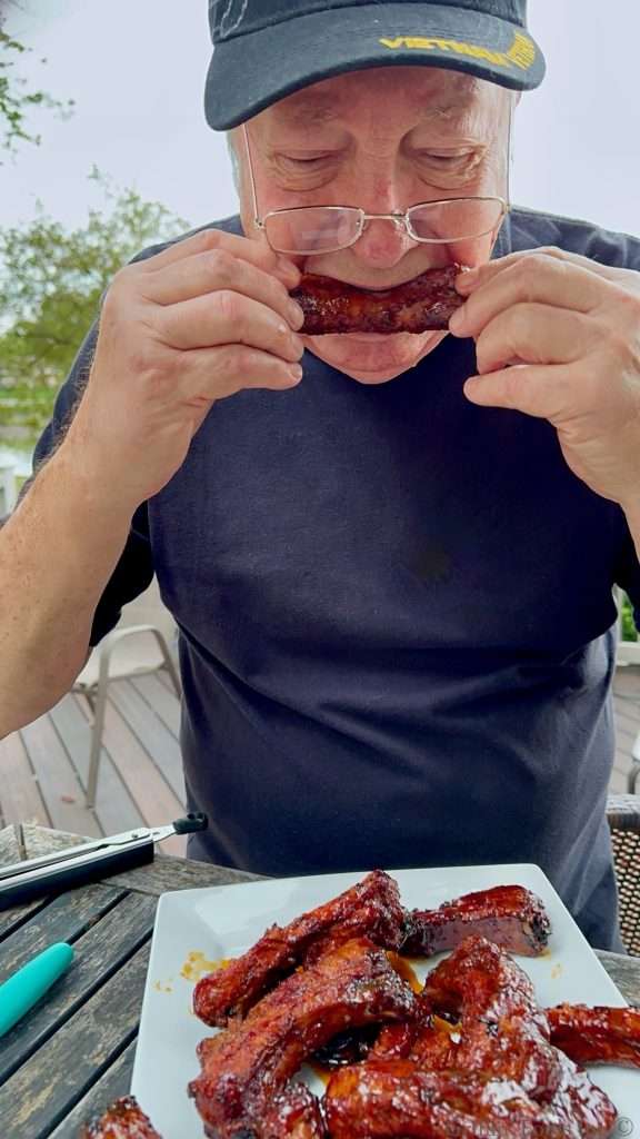 Dad taking a bite of ribs