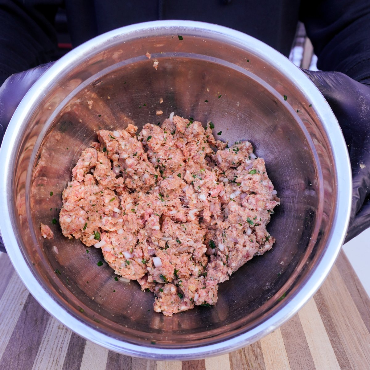 Meatball mixture in a metal bowl.