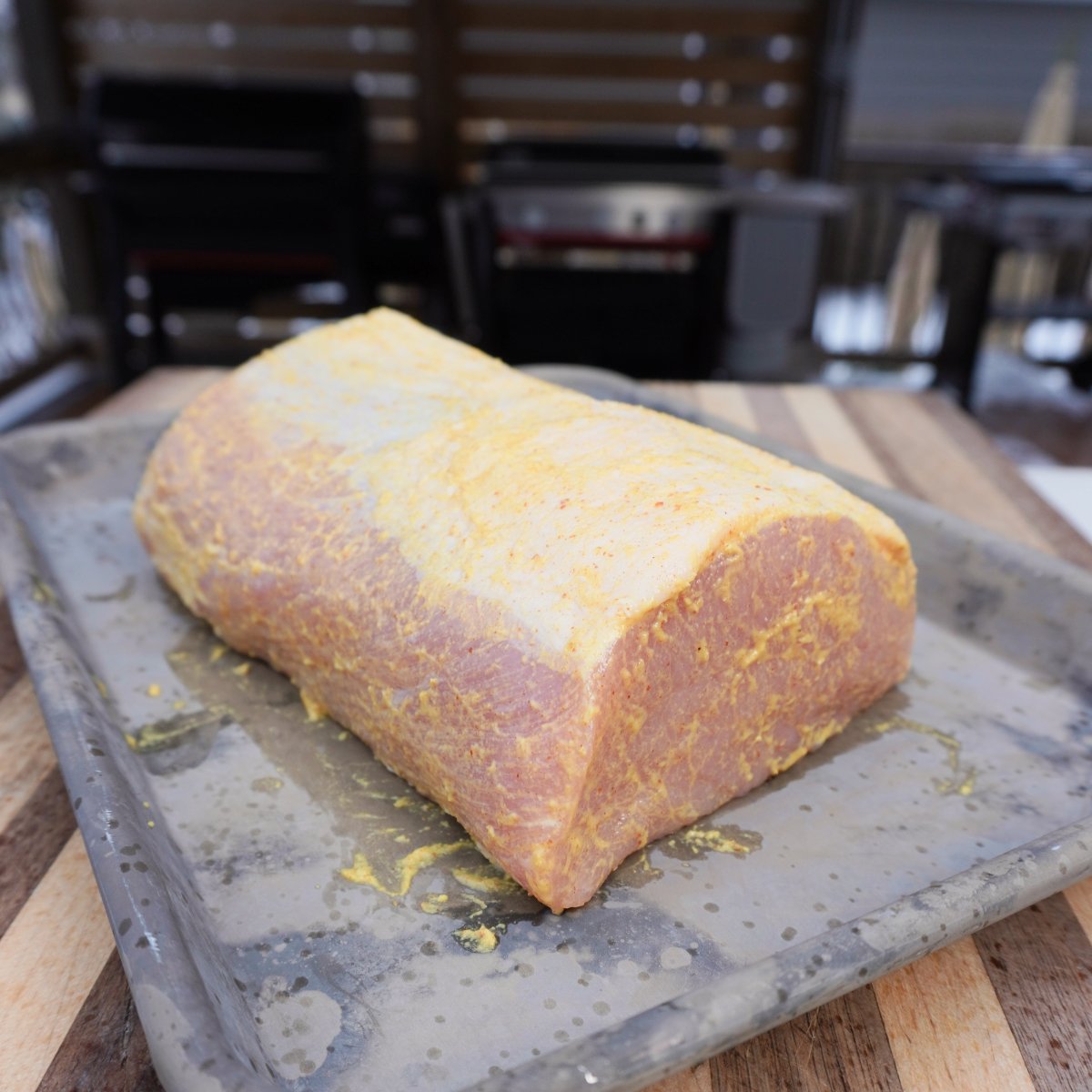 Raw pork loin covered in mustard.