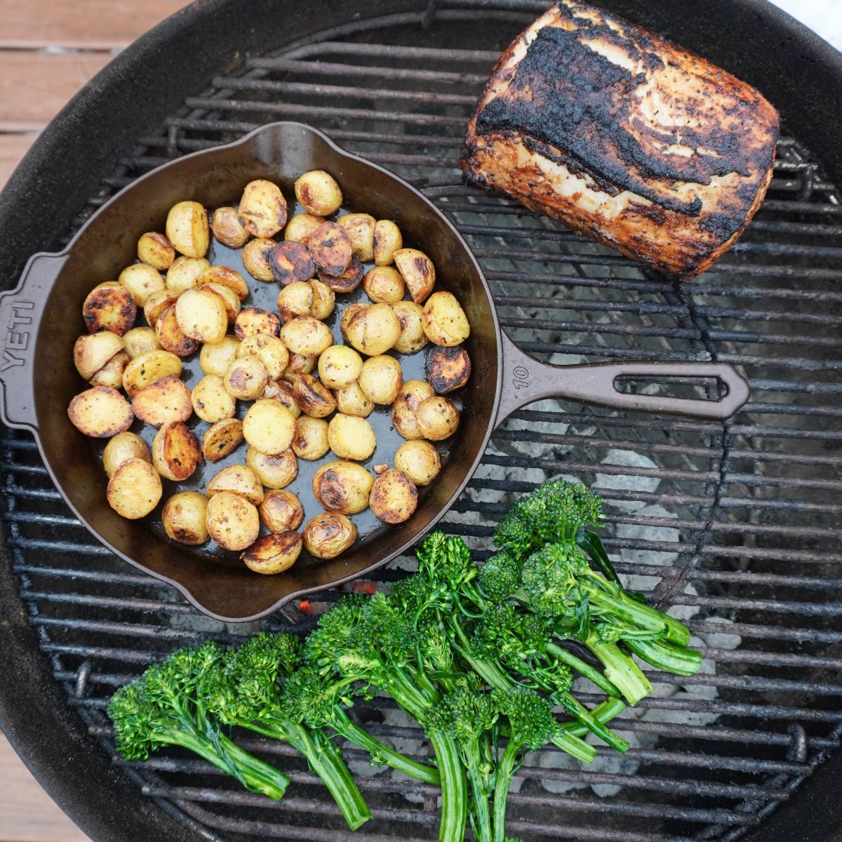 Grilled mustard pork loin, potatoes and veggies all on a charcoal grill.