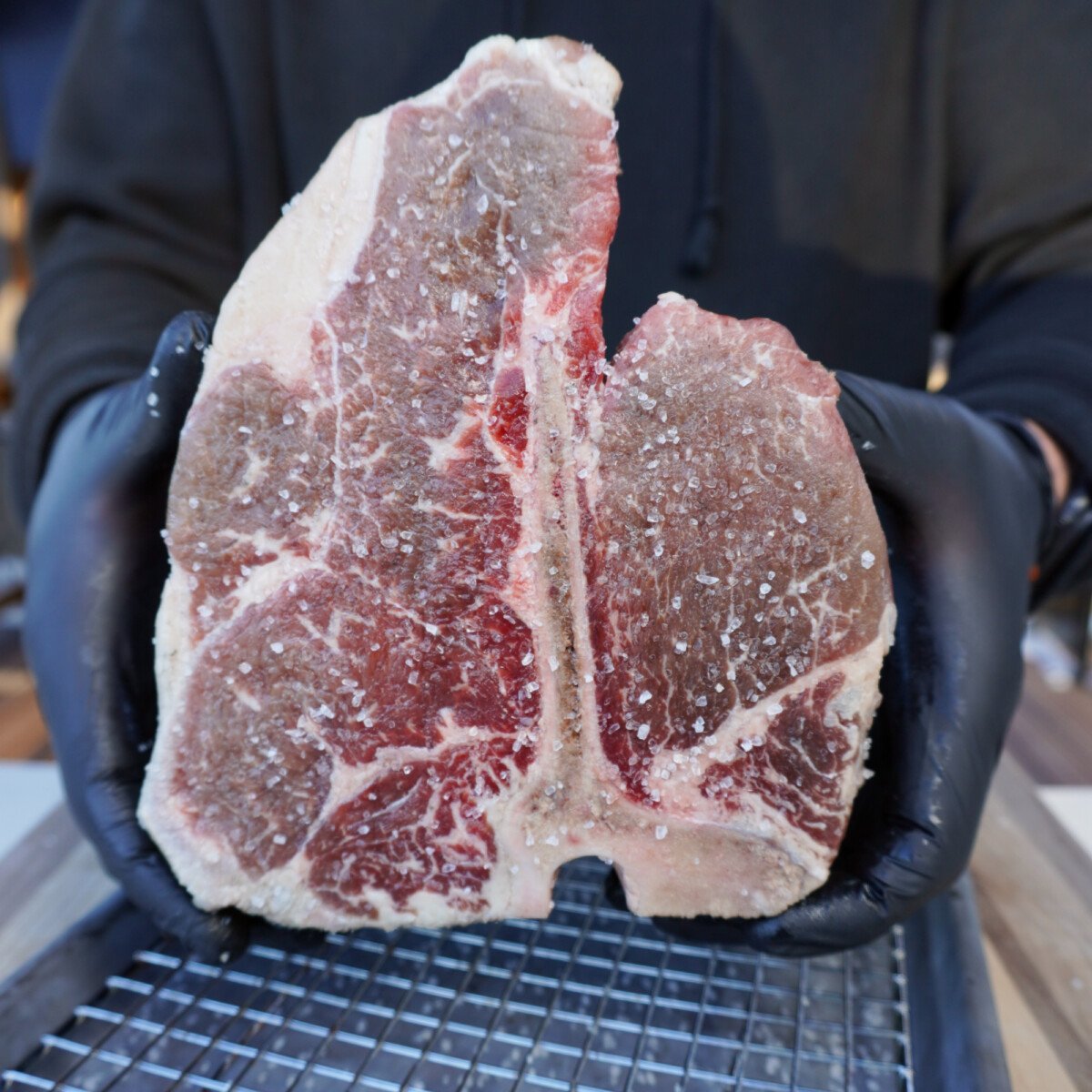 Raw seasoned porterhouse steak.