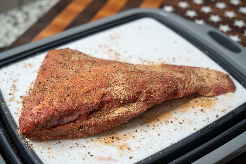 a raw seasoned piece of tri-tip