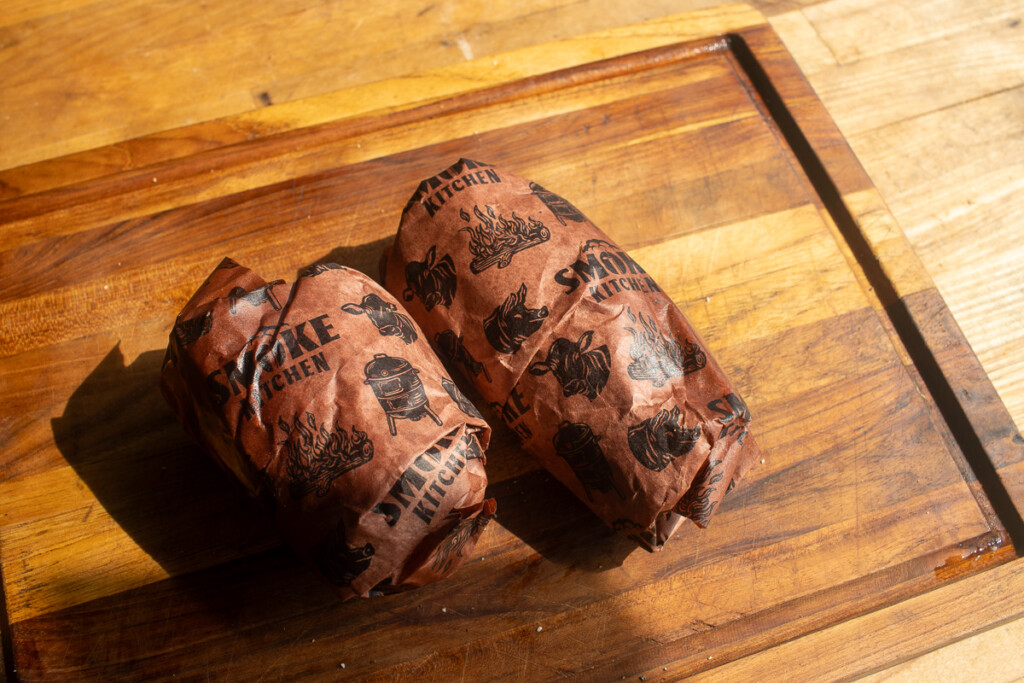 cooked potatoes in butcher paper on a wooden board