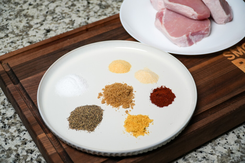 ingredients for pork chop seasoning in separate piles on a white plate