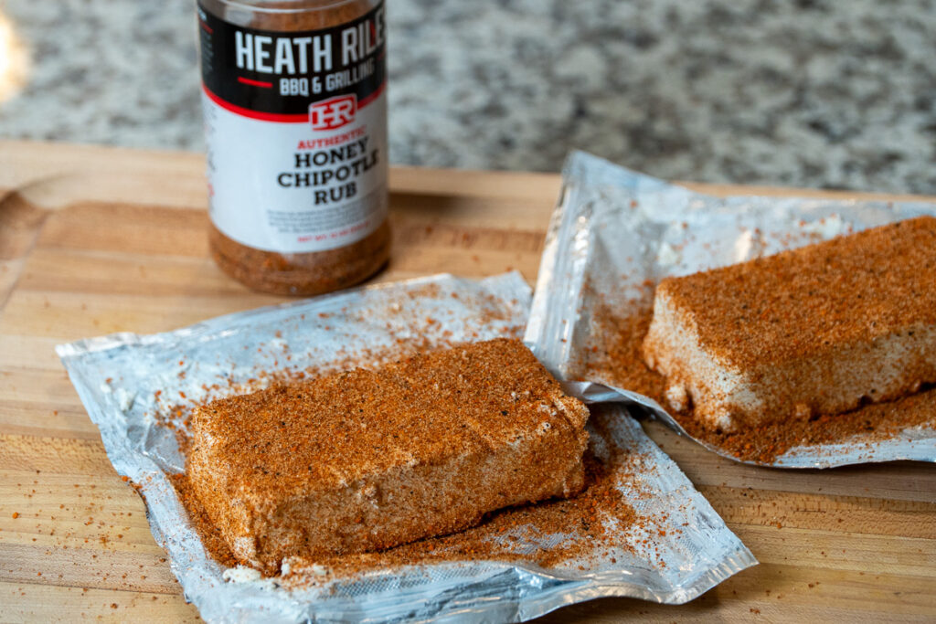  BBQ rub over a scored block of cream cheese on a baking sheet.