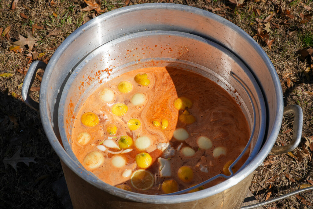 a stockpot of seasoned water with lemons, onions and garlic