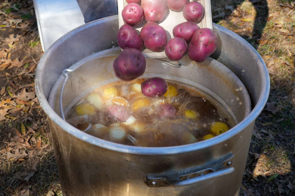 potatoes being added to a stockpot of boiling water