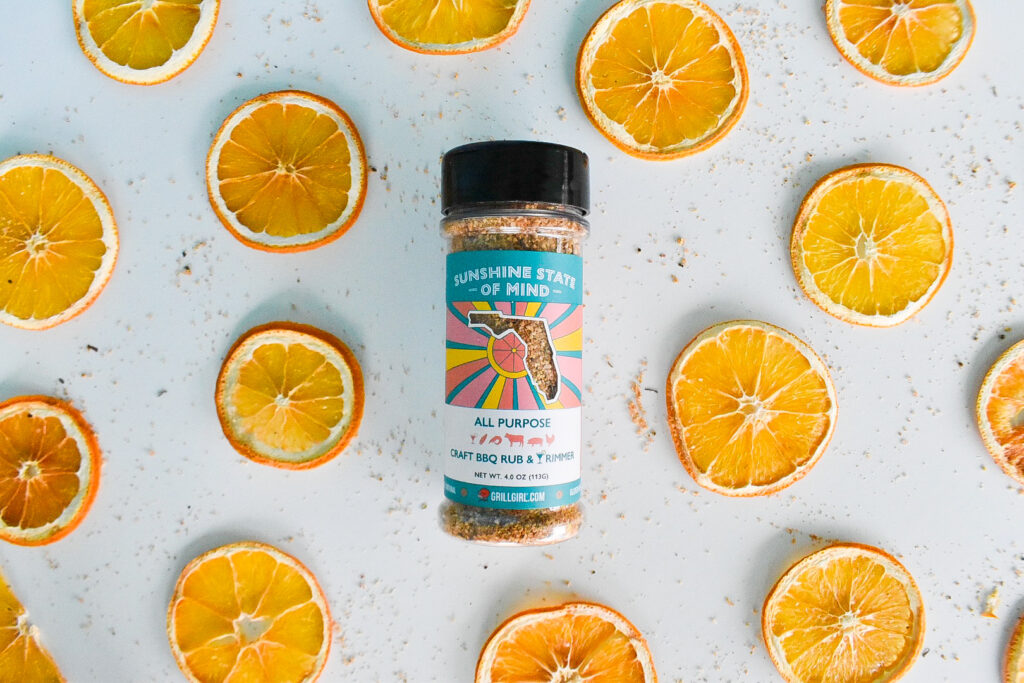 Sunshine State of Mind Rub citrus rub photographed with sliced orange peels in the background