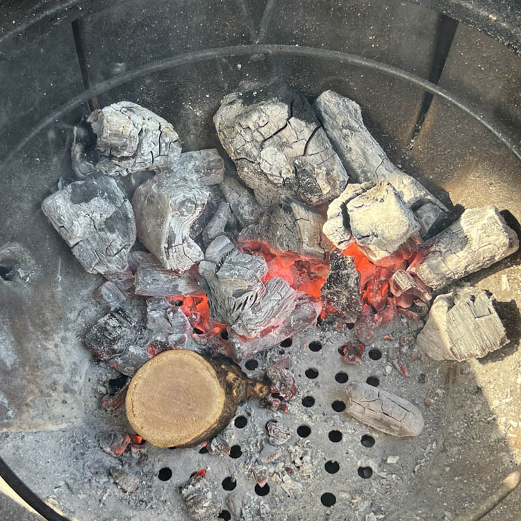 smoker set up with burn charcoal and piece of unburnt wood