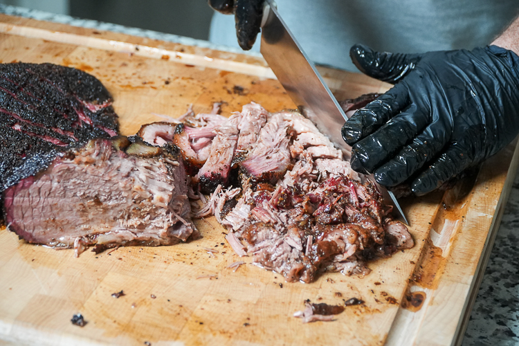 chopping brisket on a wooden chopping board