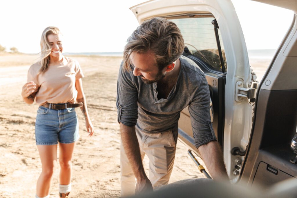 Amazing loving couple outdoors near car at the beach