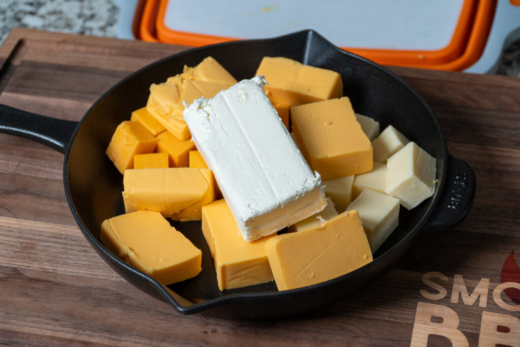 an array of cubed up cheese in a cast iron skillet