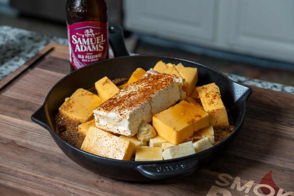 cheese in a cast iron skillet with seasoning sprinkled over the top