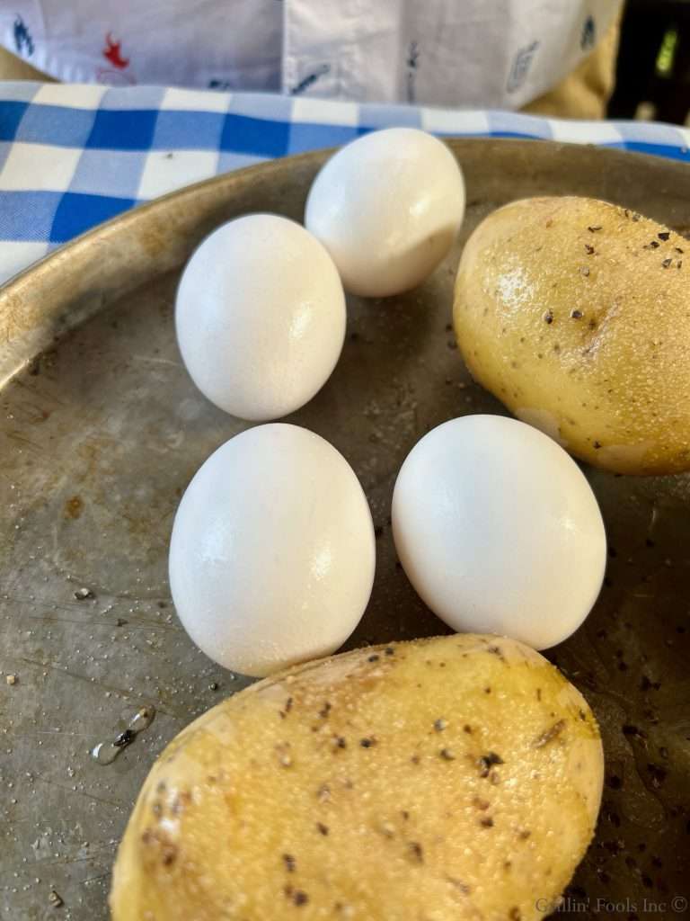Seasoned Potatoes and Raw Eggs on a Cookie Sheet