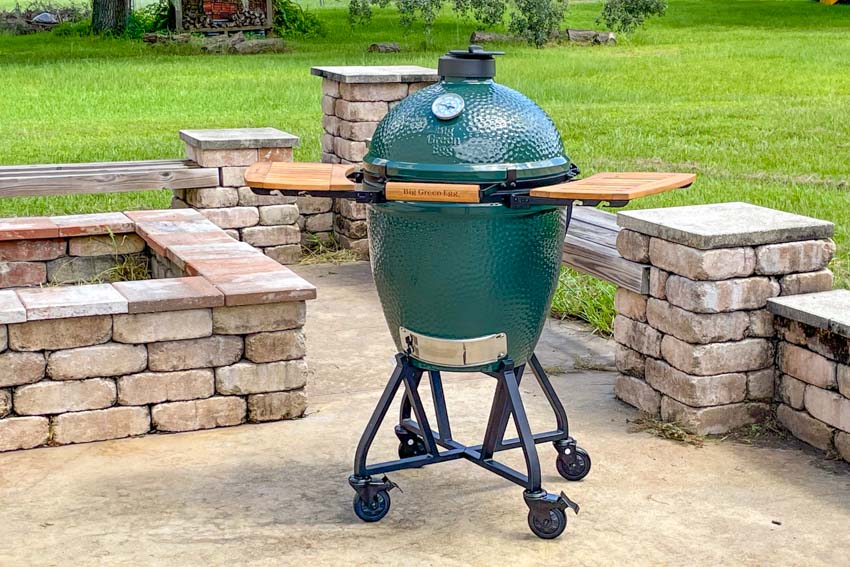 big green egg on an outdoor patio.
