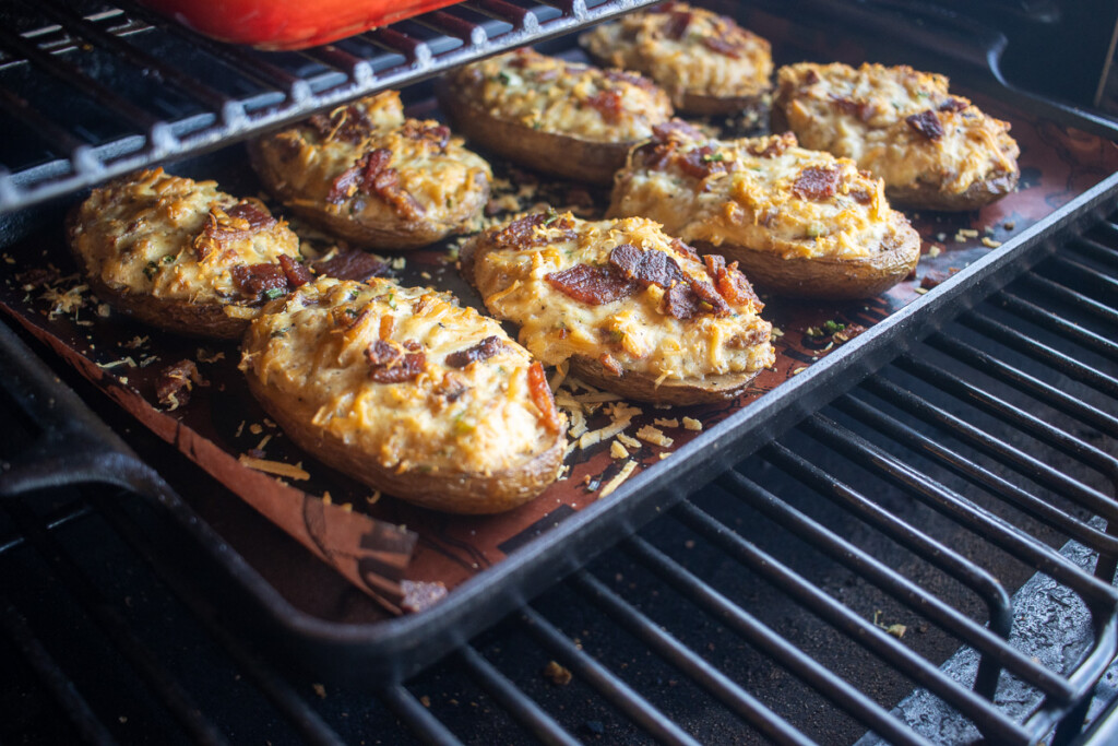smoked loaded baked potatoes on a tray in the smoker
