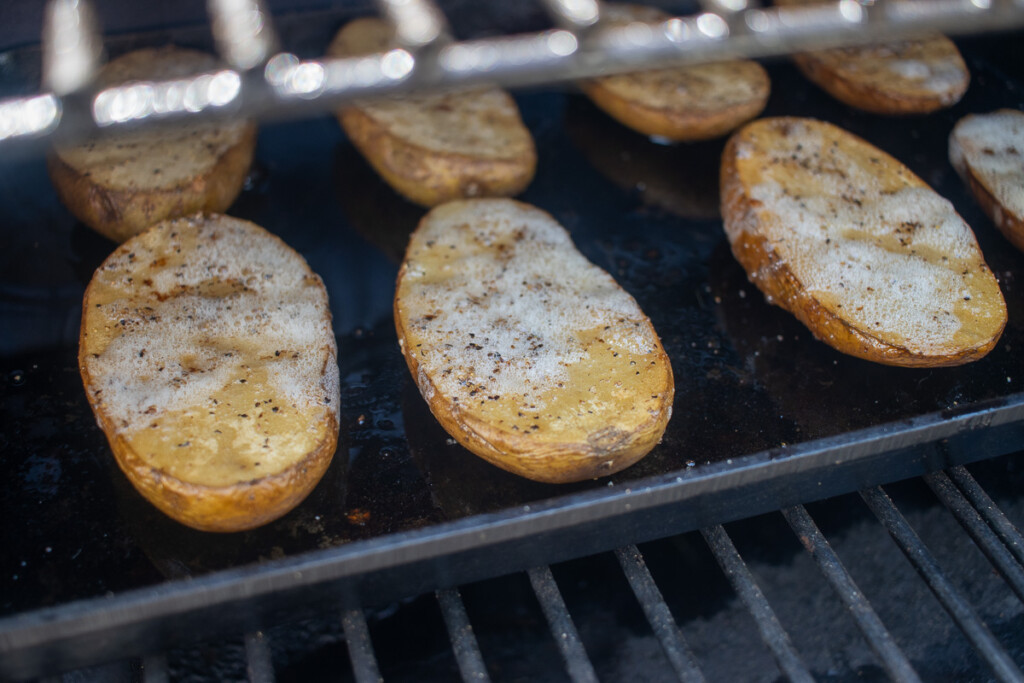 cooked, halved potatoes on the smoker