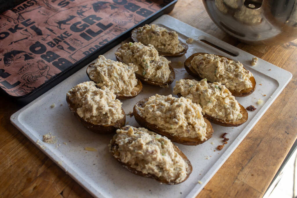 very full baked potatoe halves on a metal tray