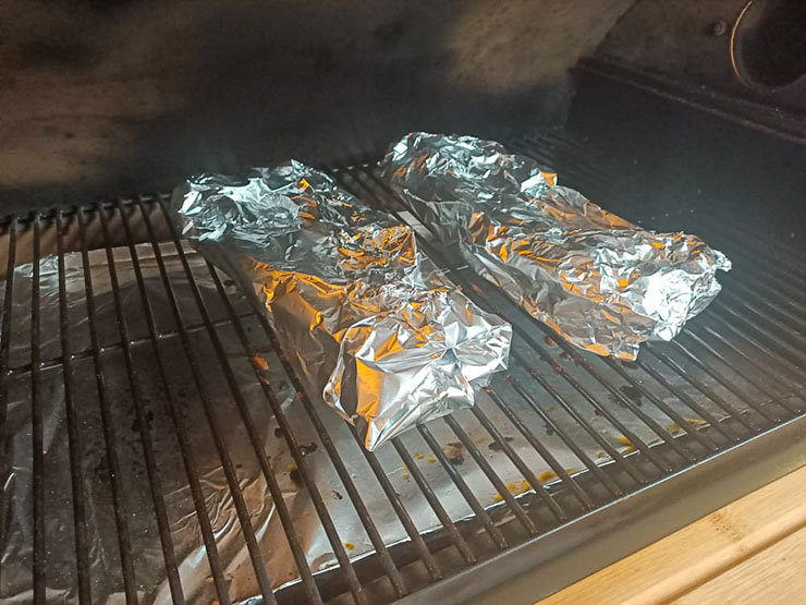 pork ribs wrapped in foil on a pellet grill