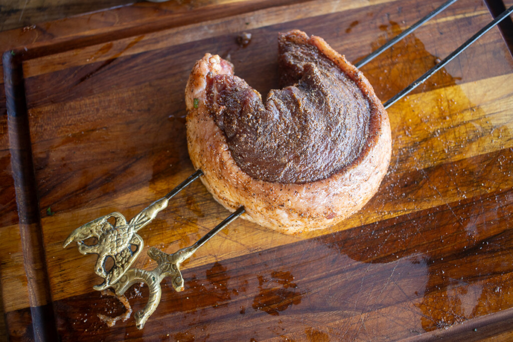 one picanha steak, curled and stuck with two skewers