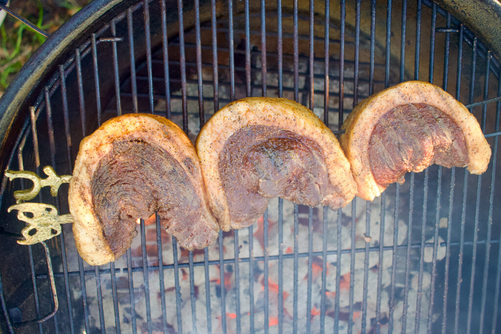 raw skewered steak on a grill over hot coals