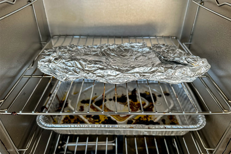 ribs wrapped in foil back in the smoker