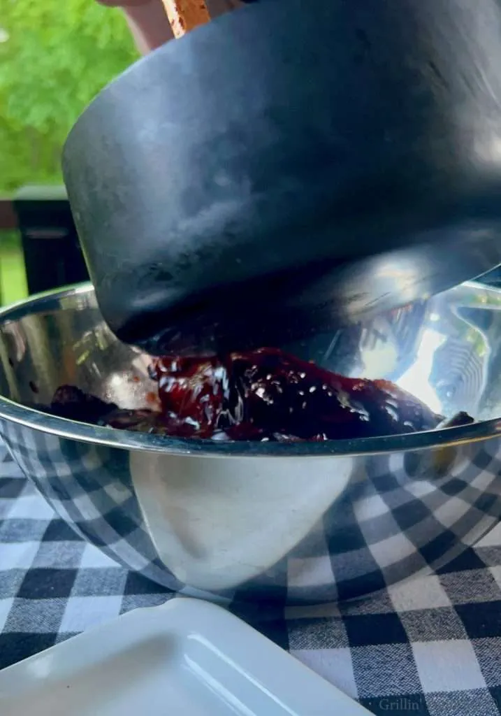 Pouring the sauce over the smoky party ribs