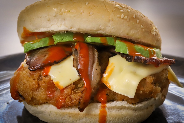 burger buns with smoked and fried buttermilk chicken thighs, cheese, bacon and avocado