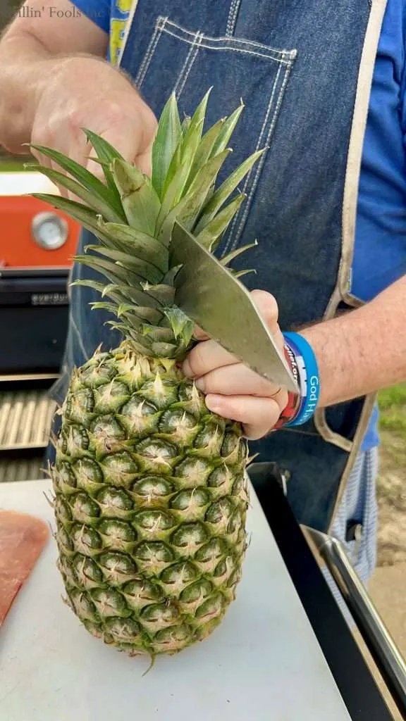 Slicing through the pineapple stem