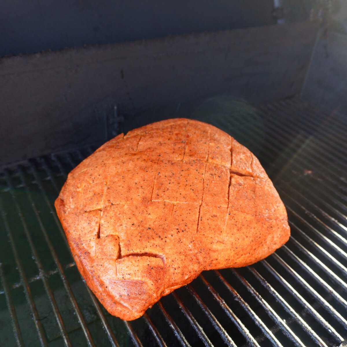 Raw seasoned pork shoulder on the grill.