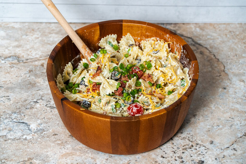 A big wooden bowl full of creamy bacon ranch pasta salad