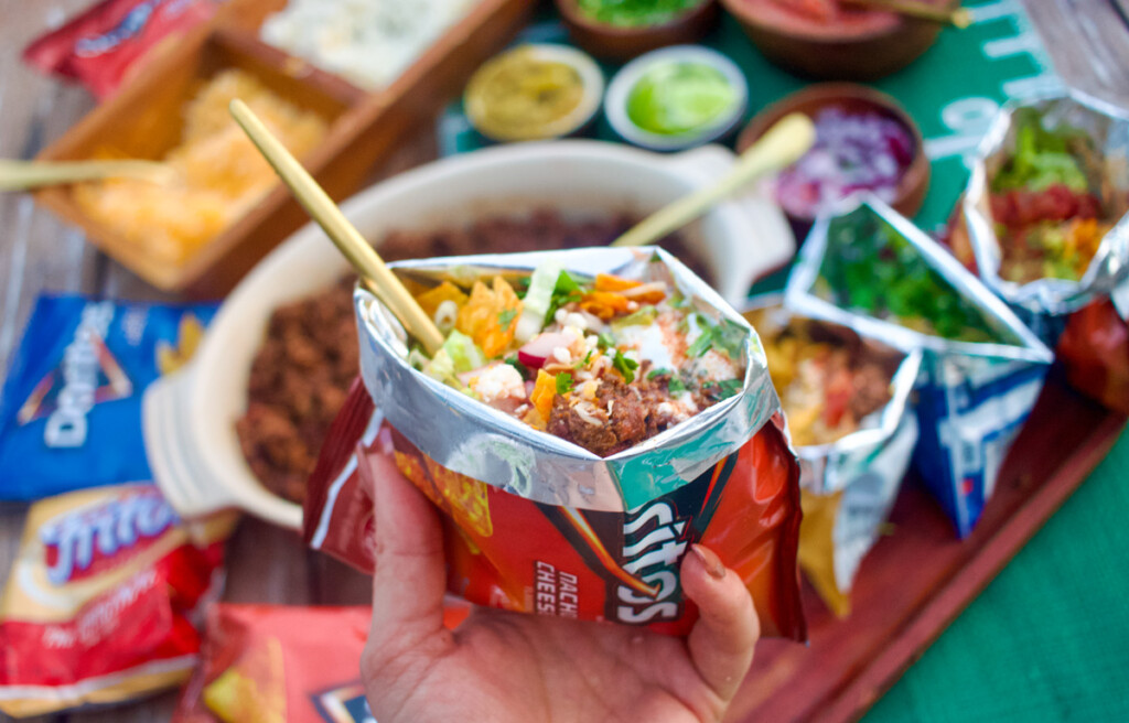 a hand holding a single bag of walking tacos