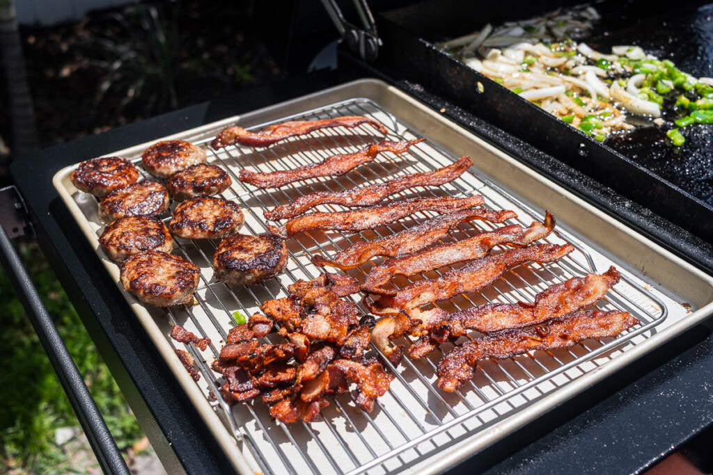 cooked bacon and sausage on a wire rack