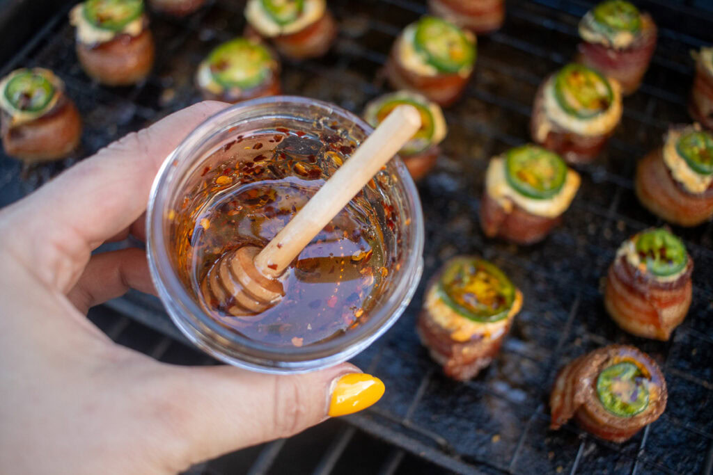 a hand holding a jar of hot honey