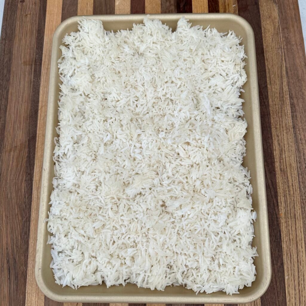 cooked rice on a large sheet pan.