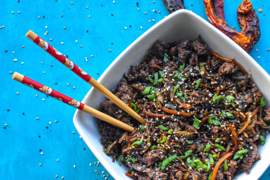 Keto Egg roll in a bowl with chopsticks sticking out.