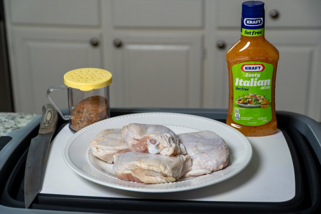 the ingredients for smoked chicken thighs laid out on a tray